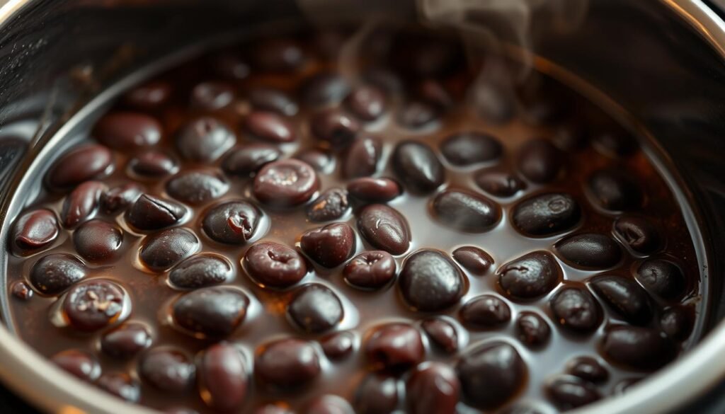 A close-up shot of a pressure cooker filled with rich, dark black beans, simmering in a savory broth. The beans are plump and glistening, with a creamy, tender texture. The pressure cooker's metallic surface reflects the warm lighting, creating a cozy, homey atmosphere. The steam rising from the pot adds a sense of warmth and anticipation. The image is shot from a slightly elevated angle, highlighting the depth and detail of the dish, inviting the viewer to imagine the aroma and taste of the perfectly cooked black beans.